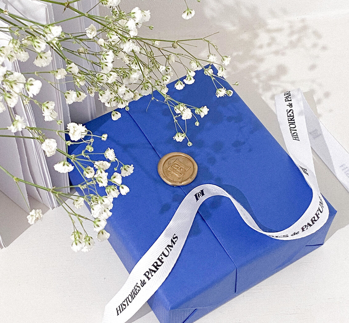 Blue gift and white ribbon on a light background